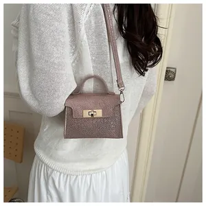 Detail of lavender textured mini bag with gold twist lock and adjustable shoulder strap