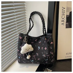 Detail of floral tote bag with butterfly patterns, woven handles and a cloud charm