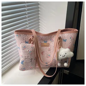 Dettaglio della borsa tote trapuntata floreale rosa con astuccio e ciondolo a nuvola