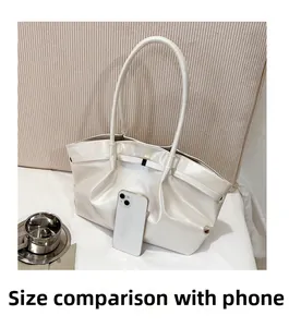 Dettaglio della borsa a mano plissettata bianco perla con smartphone per confronto