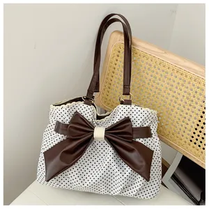 Detailed close-up of retro polka dot tote bag with lace edges and a brown leather bow
