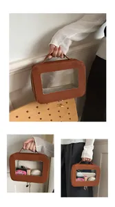 Détail d'une trousse de maquillage marron avec fenêtre transparente et poignée de voyage