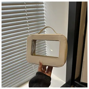 Détail de la trousse de maquillage en cuir Saffiano crème avec fenêtre et poignée