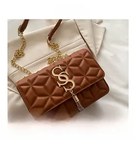 Detail showing brown quilted PU leather surface with gold fringe and chain strap