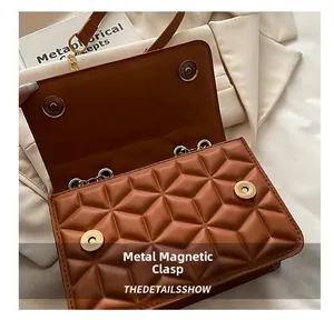 Detail showing the magnetic gold snaps and geometric quilted texture on brown leather bag