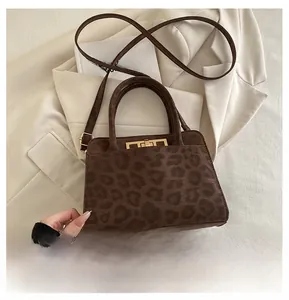 Détail du sac léopard avec fermoir en métal à côté d'un smartphone pour la taille