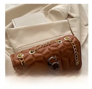 Close-up of caramel brown quilted PU leather bag with gold chain and GS metal logo