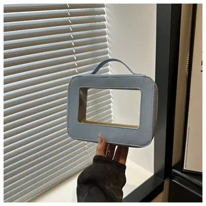 Détail du sac cosmétique bleu clair montrant le cuir PU grainé et la fenêtre transparente