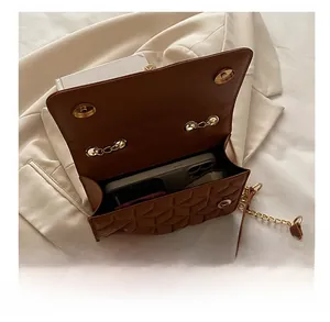 Detail view of the brown quilted crossbody bag showing spacious interior with a smartphone