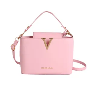 Pink minimalist bucket bag for women with gold V hardware and adjustable shoulder strap