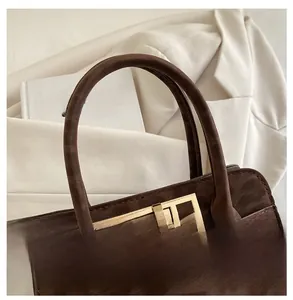 Détail du sac à main marron foncé gaufré léopard avec fermoir rotatif en métal doré