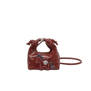 Red mini drawstring bag with heart dots and horse embroidery on a white background