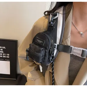 Detail of mini black nylon shoulder bag with adjustable strap and zipper pockets