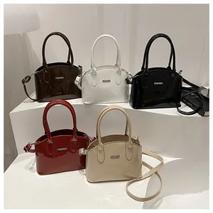 Glossy leather handbags in five colors with metal Fashion emblem on white display