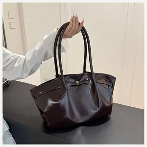 Dettaglio della borsa tote marrone scuro in pelle lucida con fibbia in metallo
