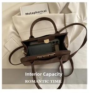 Vue de la capacité interne du sac en daim marron foncé avec téléphone et portefeuille