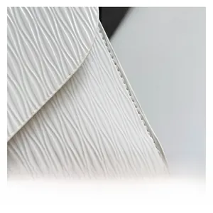 Gros plan sur un tissu blanc à texture gaufrée avec coutures soignées pour sac à main