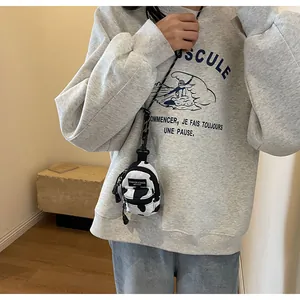 Mini cow print shoulder bag shown on model with dual zipper and long neck strap