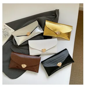 Détail des pochettes enveloppes de soirée avec fermoirs cœur doré en cinq couleurs
