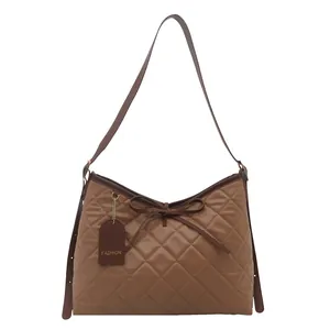 Brown quilted tote bag with bow detail and adjustable shoulder strap for women