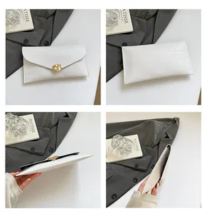 Vue détaillée de la pochette enveloppe blanche avec textures et fermoir doré