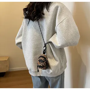Detailed shot of mini leopard print shoulder bag with zippers and crossbody strap
