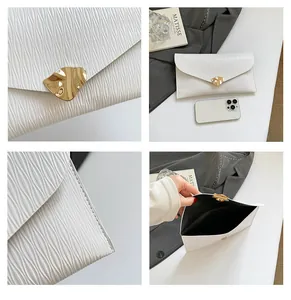 Détail d'une pochette blanche texturée avec boucle dorée et rangement interne mobile