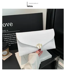 Pochette de soirée enveloppe blanche avec boucle en métal doré sur un décor épuré