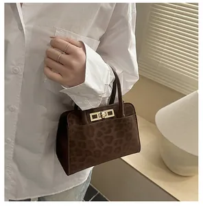 Détail d'un petit sac cabas en daim à imprimé léopard avec un fermoir en métal doré chic