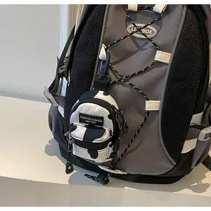 Close-up of cow print mini bag charm attached to a backpack as a stylish accessory