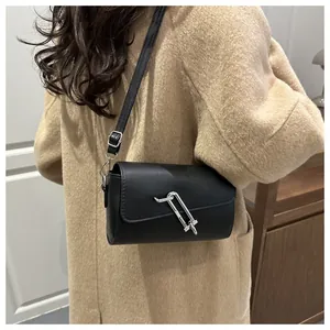 Detailansicht der schwarzen Baguette-Tasche aus Leder mit silberner Schnalle am Mantel