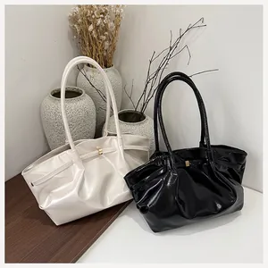 Détail de sacs fourre-tout plissés en cuir brillant blanc perle et noir avec fines anses