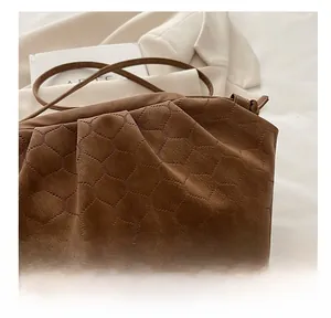 Detail showing brown cloud bag with honeycomb embossed texture and delicate pleats