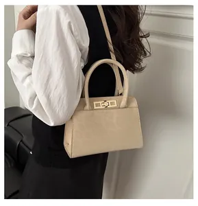 Détail de la texture léopard beige gaufrée et fermoir rotatif doré sur le sac à main