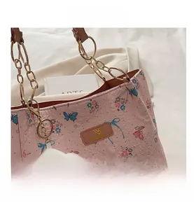Pink butterfly tote bag featuring gold chain strap and fluffy cloud pendant detail