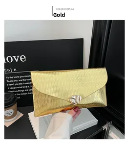 Détail de la pochette enveloppe dorée avec texture métallique ondulée et boucle