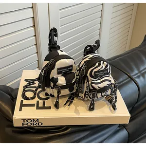 Mini backpack coin pouches in cow and zebra prints with functional hooks and zippers