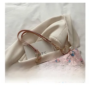 Macro detail of the 3D floral and butterfly textured fabric on this pink tote bag