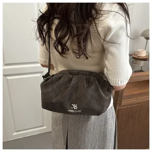 Detail view of charcoal crossbody bag with quilted honeycomb texture and leather strap