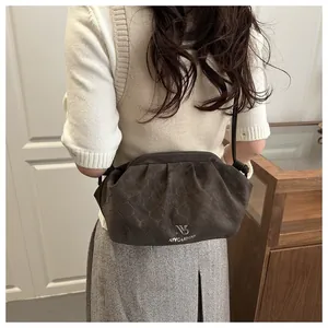 Detailed view of dark brown cloud bag with geometric embossed texture and silver logo