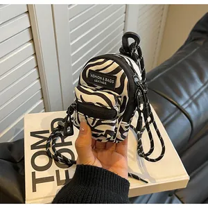 Close-up of mini zebra print shoulder bag with woven lanyard and fashion leather label