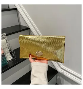 Vue détaillée de la pochette enveloppe dorée avec texture ondulée et fermoir feuille