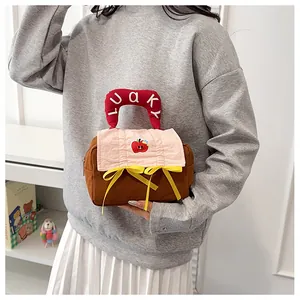 Detailaufnahme der Kosmetiktasche aus Baumwolle mit Apfel-Stickerei und rosa Schleife