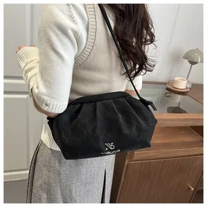 Detail of black quilted crossbody bag showing honeycomb texture and silver metal logo