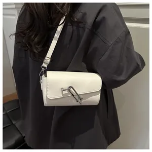 Schicke cremeweiße Umhängetasche mit Silberverschluss am Modell für einen trendigen Stil