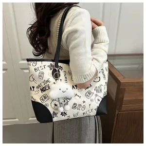Detail of printed tote bag featuring graffiti patterns and cute cloud charm accessory