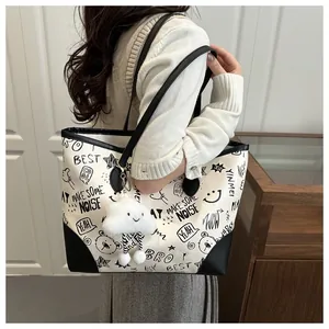 Detail view of large graffiti tote bag featuring street art prints and plush cloud charm