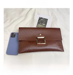 Pochette en cuir PU plissé marron avec boucle dorée comparée à un smartphone
