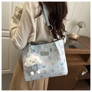 Detail of light blue butterfly tote bag featuring jacquard fabric and cloud plush charm