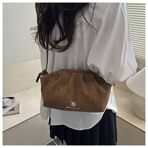 Detailed view of brown cloud bag with geometric embossed texture and metal logo